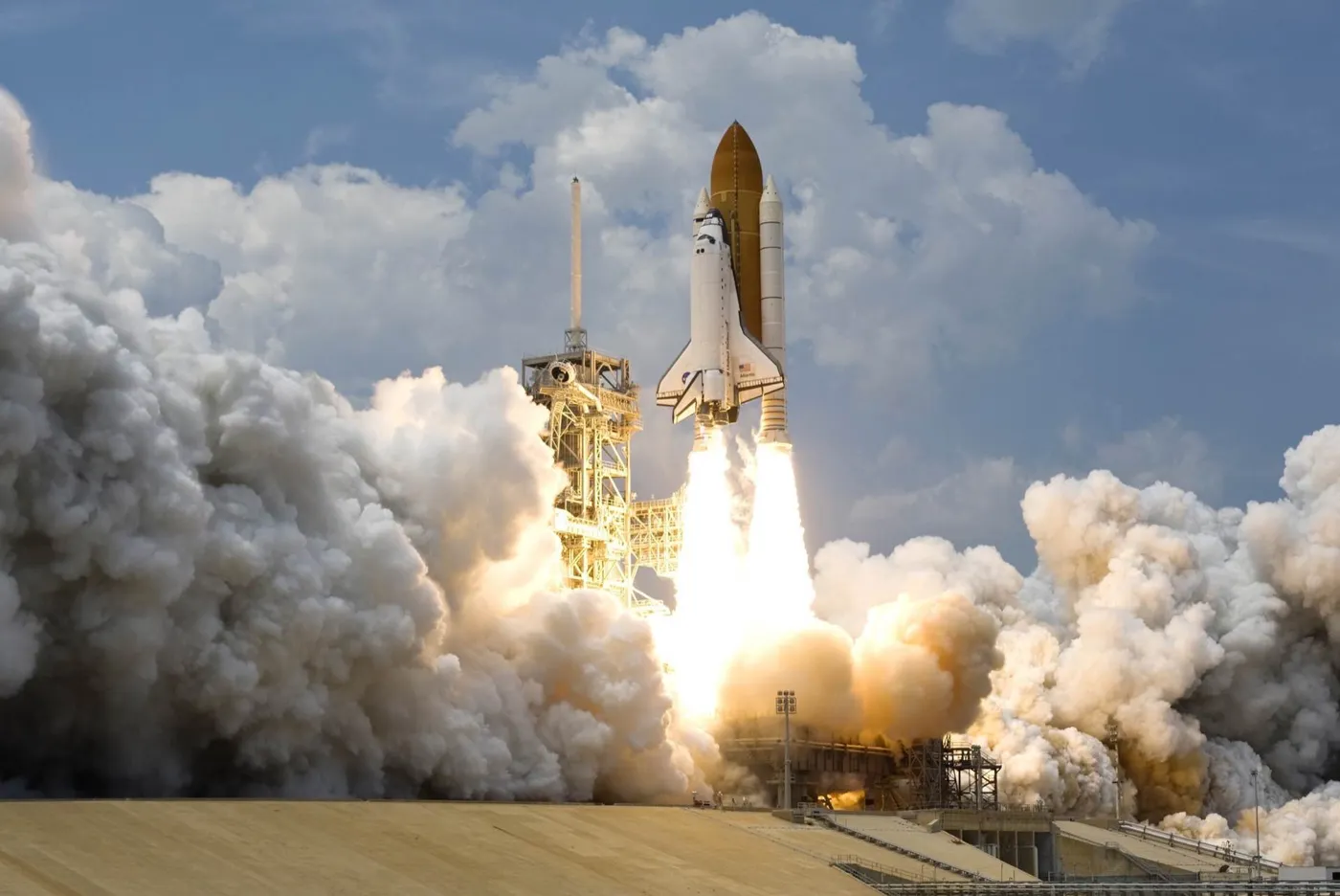 A space shuttle lifting off in a cloud of smoke