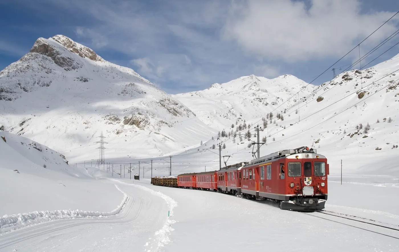 A red train through snowy mountains